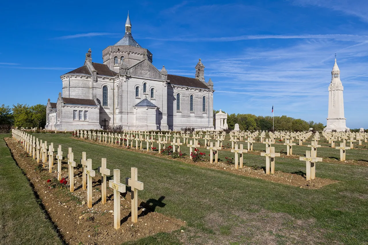La basilique et la tour-lanterne de Notre-Dame-de-Lorette au-dessus des rangées de croix de la nécropole, sous un ciel bleu